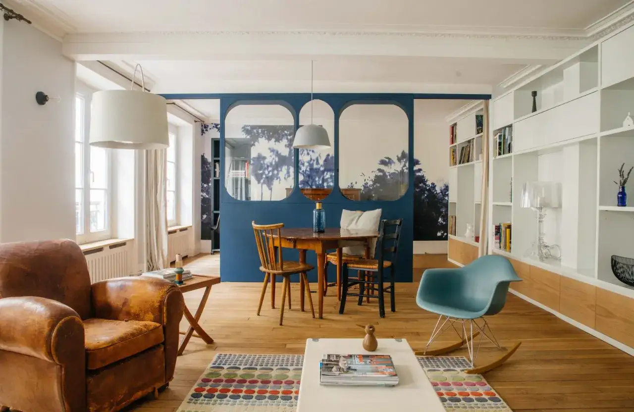 Une porte coulissante bleue permet de s&eacute;parer une pi&egrave;ce en deux sans travaux, cr&eacute;ant deux espaces distincts avec un salon et une salle &agrave; manger.
