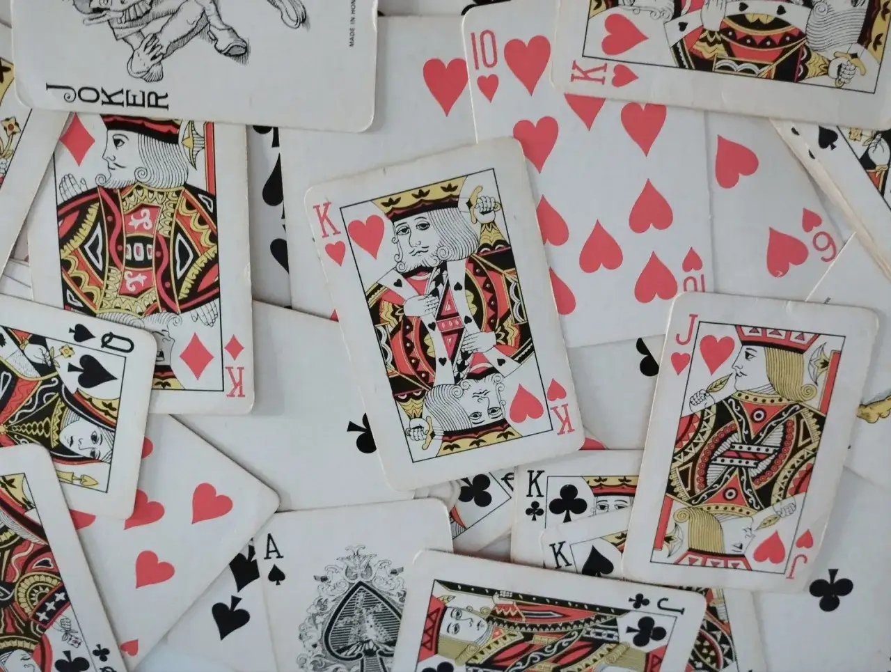 Un mazzo di carte da gioco sparse, con re, donne, jack e un jolly. Sembra un gioco per indovinare il numero pensato senza calcoli.