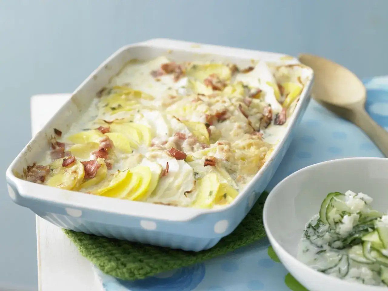 Herzhafter Kartoffel Kohlrabi Auflauf mit Speck, cremig überbacken. Dazu ein frischer Gurkensalat.