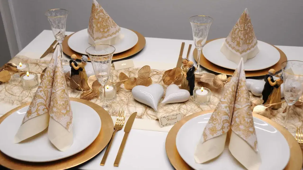 Festlich gedeckter Tisch mit goldenen Akzenten, Kerzen und Figuren eines tanzenden Paares. Ein Symbol f&uuml;r die Bedeutung eines 75. Hochzeitstages.