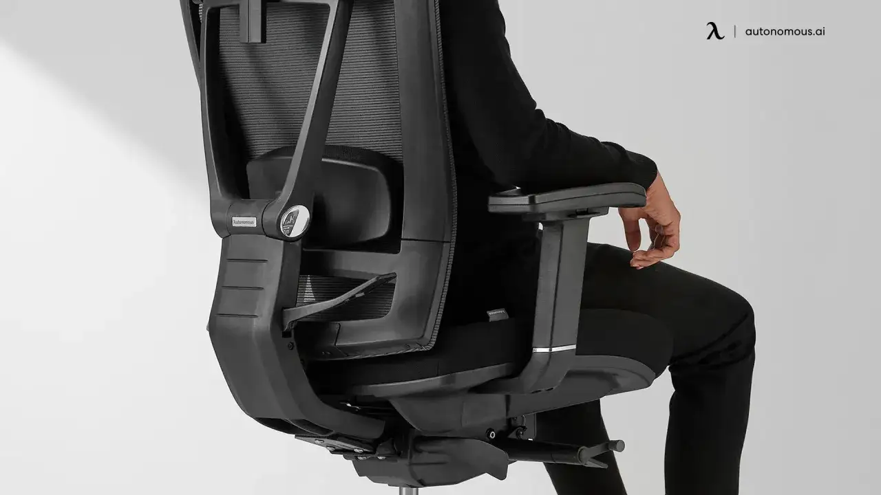 Personne assise dans un fauteuil ergonomique noir, montrant comment bien s'asseoir pour un confort optimal.