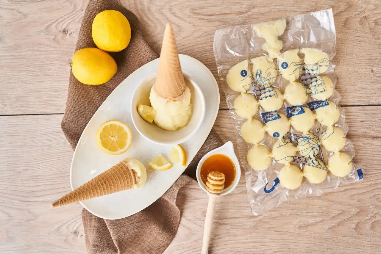Citronglass med citronskivor, strutar och en sked honung. Perfekt f&ouml;r ett snabbt lemon curd recept.