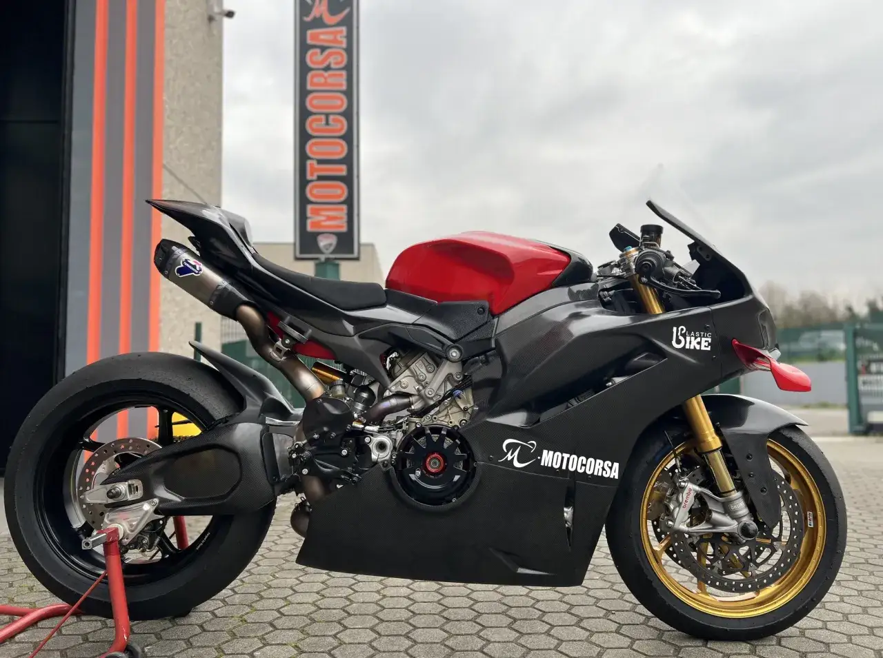 Czarny Ducati Panigale V4 z czerwonym bakiem, gotowy do jazdy.