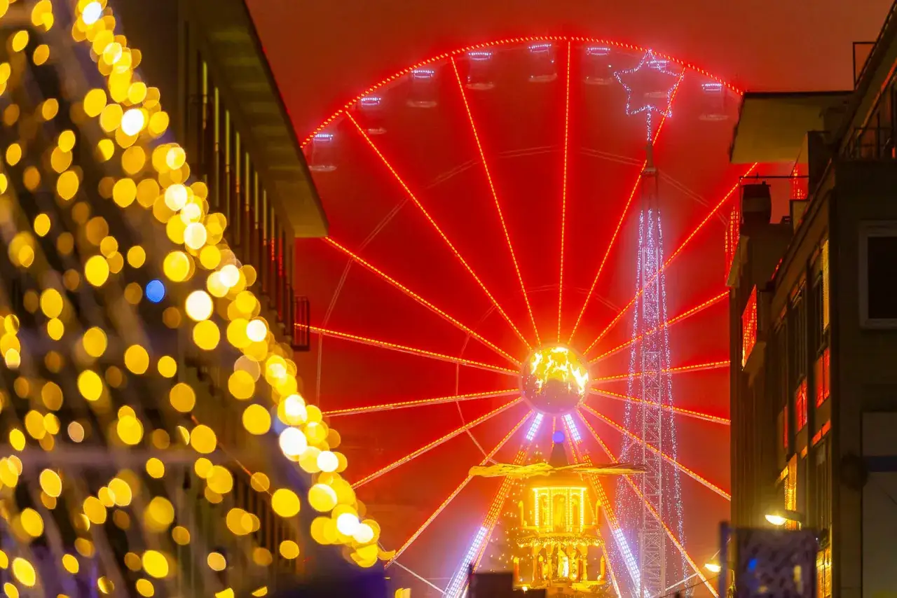 Glitzerndes Riesenrad in Karlsruhe, umgeben von Weihnachtsbeleuchtung. Ein magischer Anblick bei Nacht.