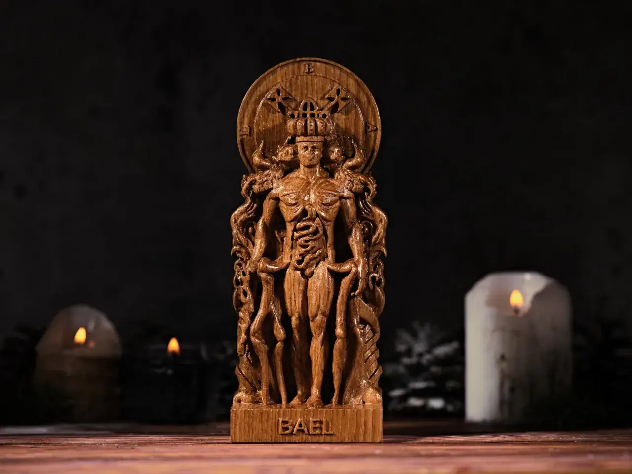 Drewniana rzeźba przedstawia Baala, demonicznego władcę, z koroną i wieloma twarzami. Otoczony jest wężami i symbolami.