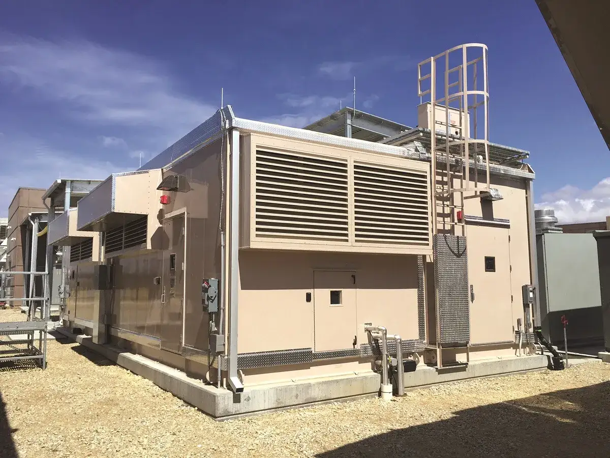 Un **data center extérieur** moderne avec des unités de climatisation imposantes et une échelle menant au toit.