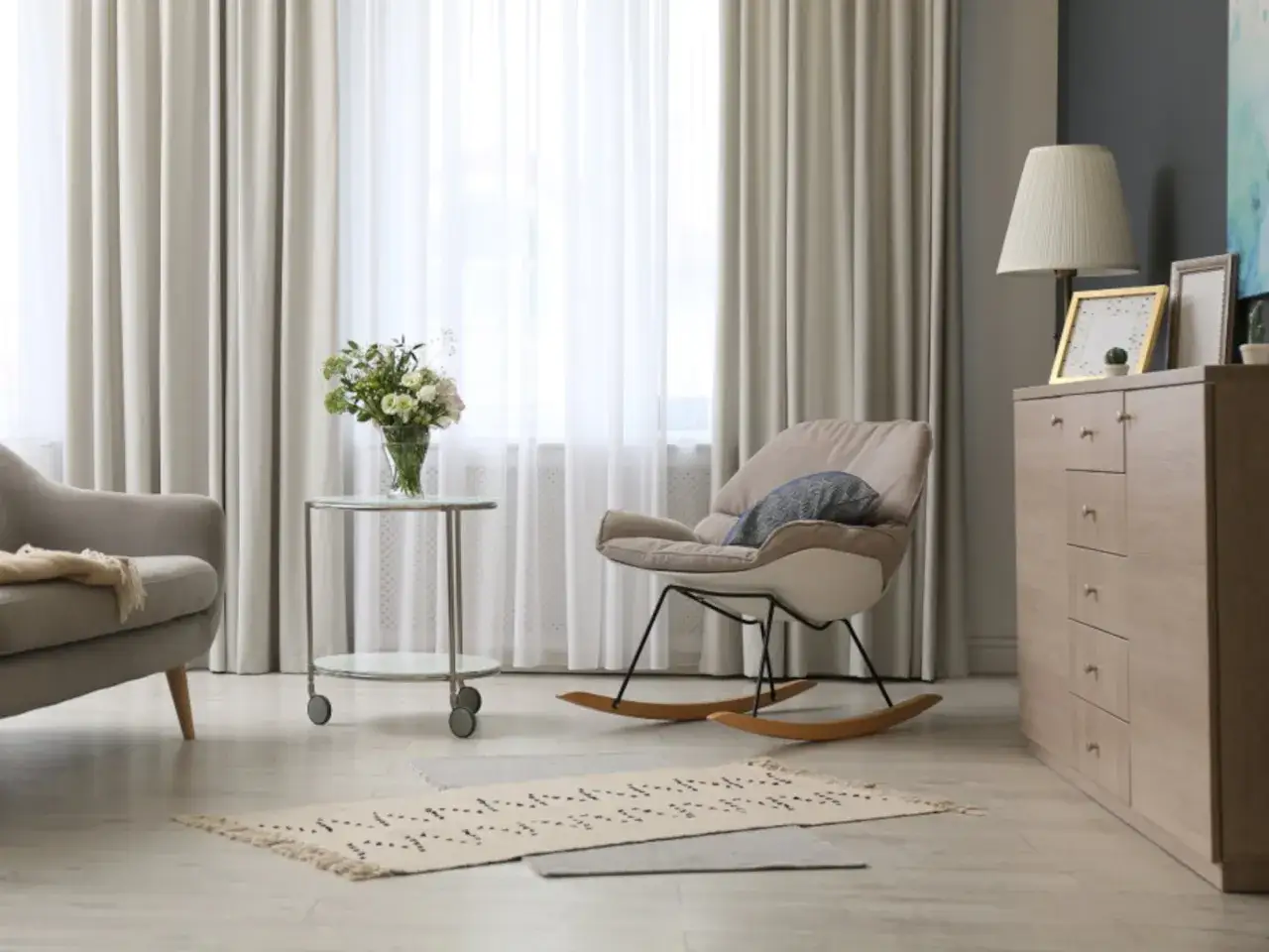 Elegantes cortinas de sal&oacute;n, un sill&oacute;n mecedora y un jarr&oacute;n con flores. Las &uacute;ltimas tendencias en cortinas para tu sal&oacute;n.