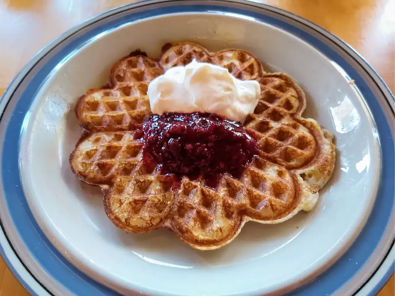 En hjärtformad våffla med sylt och grädde. Perfekt för att värma våfflor i ugnen för en mysig fika.