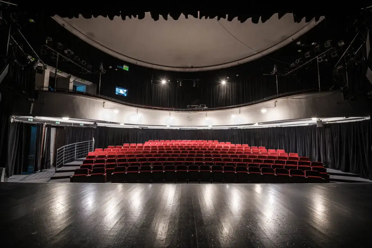 Pusta sala teatralna z rzędami czerwonych foteli. Czekamy na krotochwilę, co to będzie?