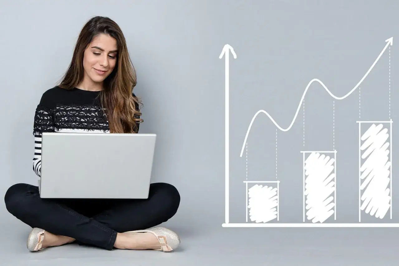 Jeune femme travaillant sur son ordinateur portable, symbolisant son **master économie à distance** et sa progression vers le succès.