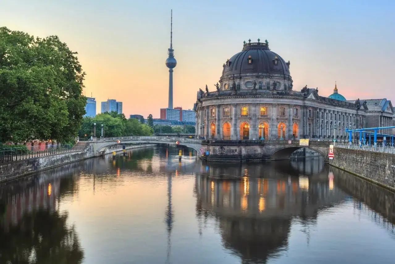 Romantische date ideen berlin: Spaziergang an der Spree mit Blick auf das Bode-Museum und den Fernsehturm bei Sonnenuntergang.
