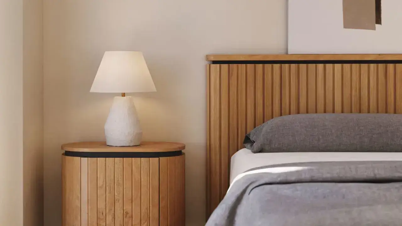 Renovar dormitorio sin cambiar muebles: mesita de noche de madera con l&aacute;mpara y cabecero de listones.