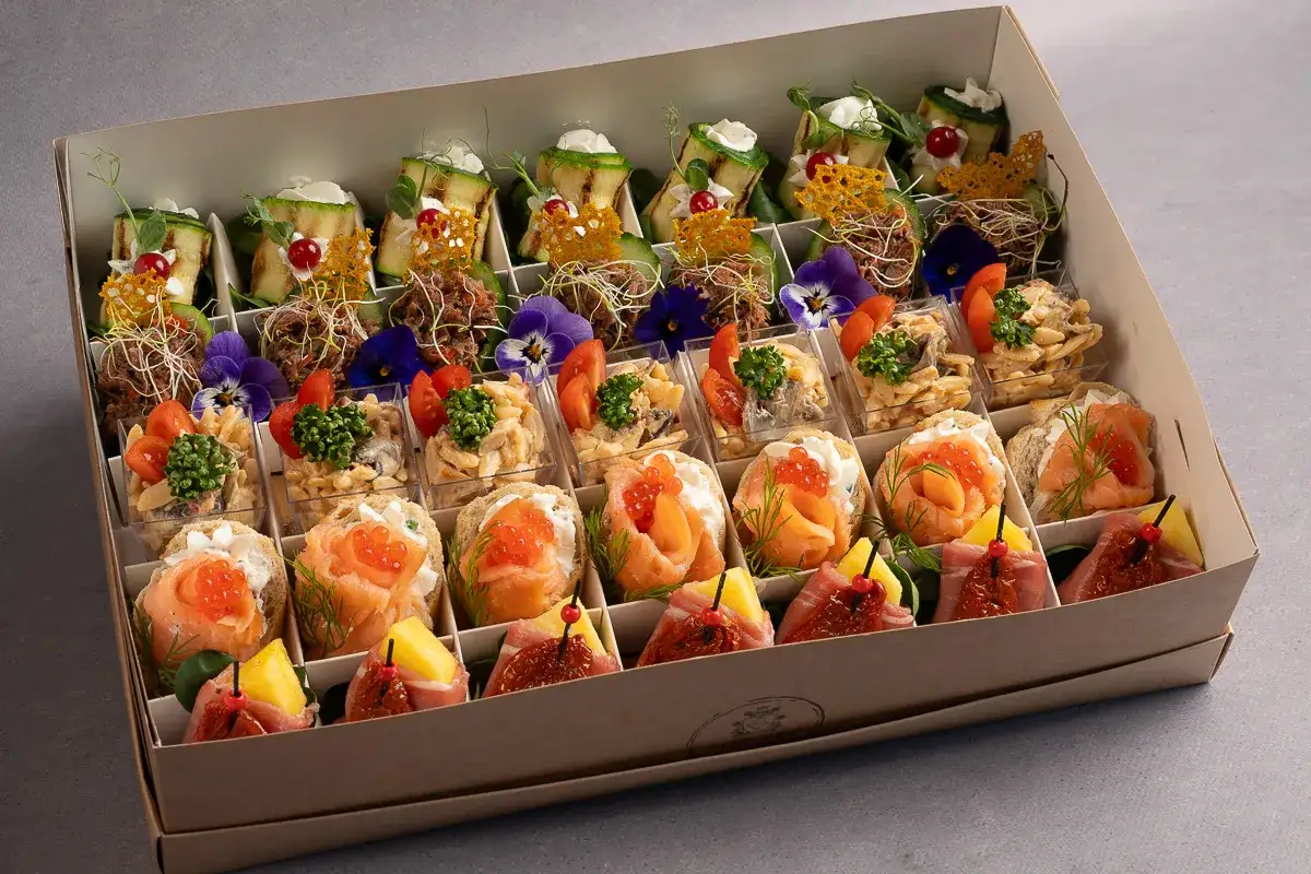 Eleganckie finger food opakowania z łososiem, warzywami i kwiatami. Idealne na przyjęcie.
