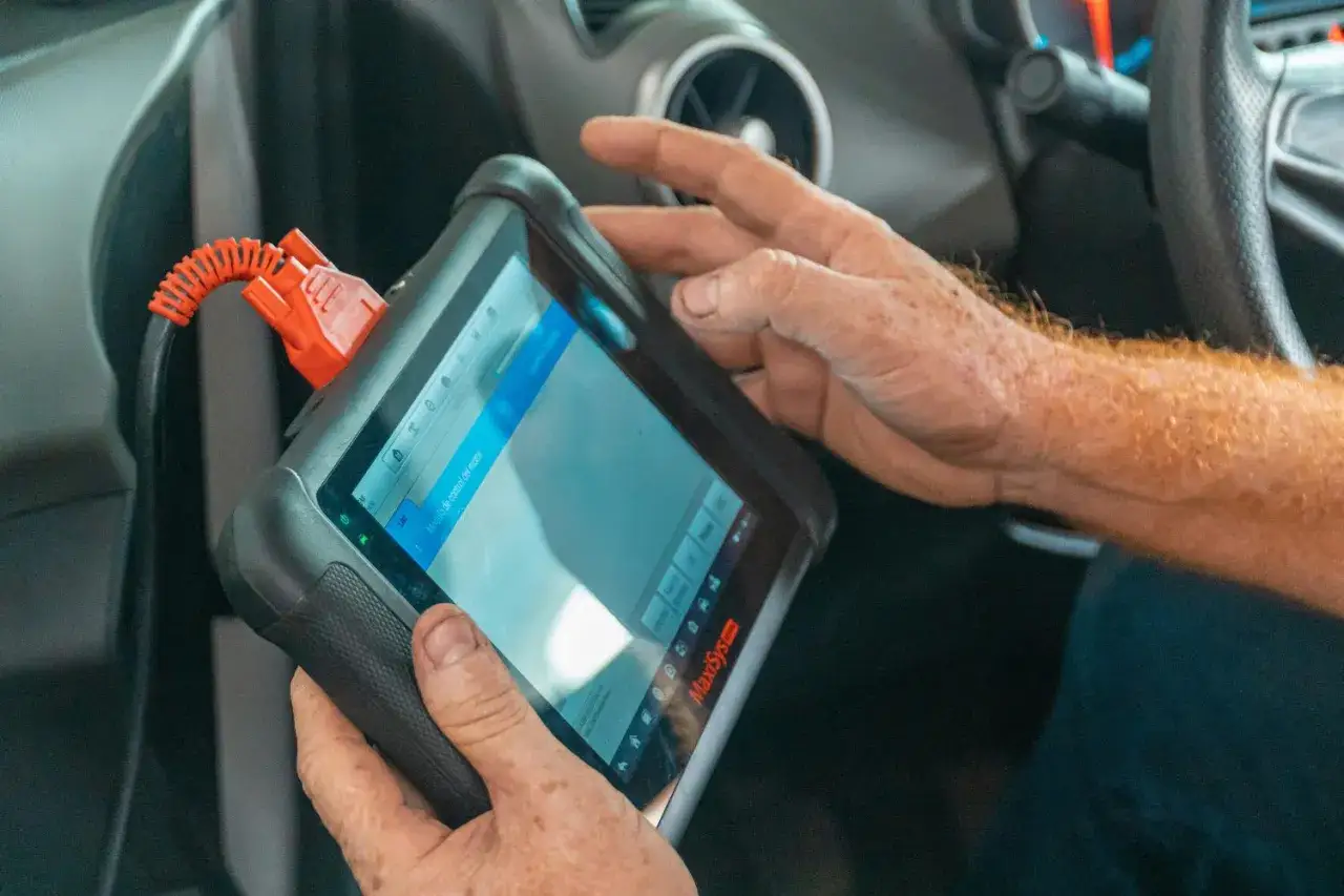Mechanik diagnozuje auto za pomocą skanera, porównując dane z systemów OBD2 vs OBD1.
