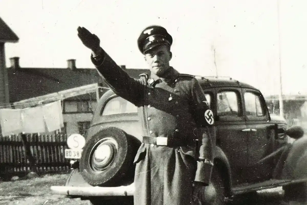 En man i uniform med hakkors hälsar. Bilden visar en historisk scen med svenska nazister.