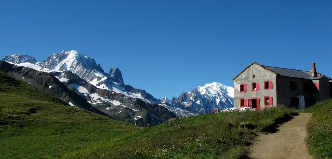 Refuge de montagne avec vue sur le Mont-Blanc enneigé, idéal pour une étape du tour du Mont-Blanc en 3 jours.