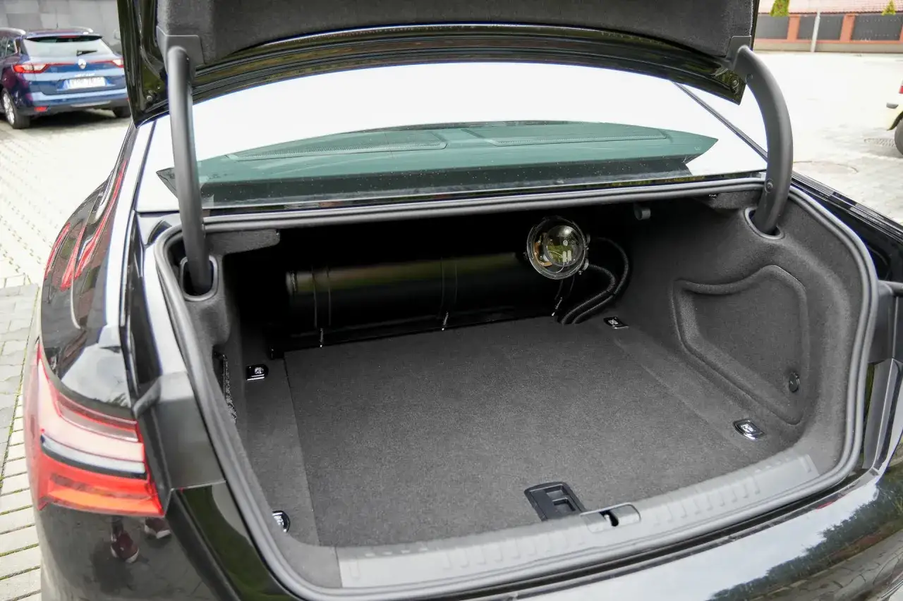 Bagażnik Audi A6 C6 2.4 benzyna z zamontowaną instalacją LPG. Zbiornik gazu zajmuje część przestrzeni.