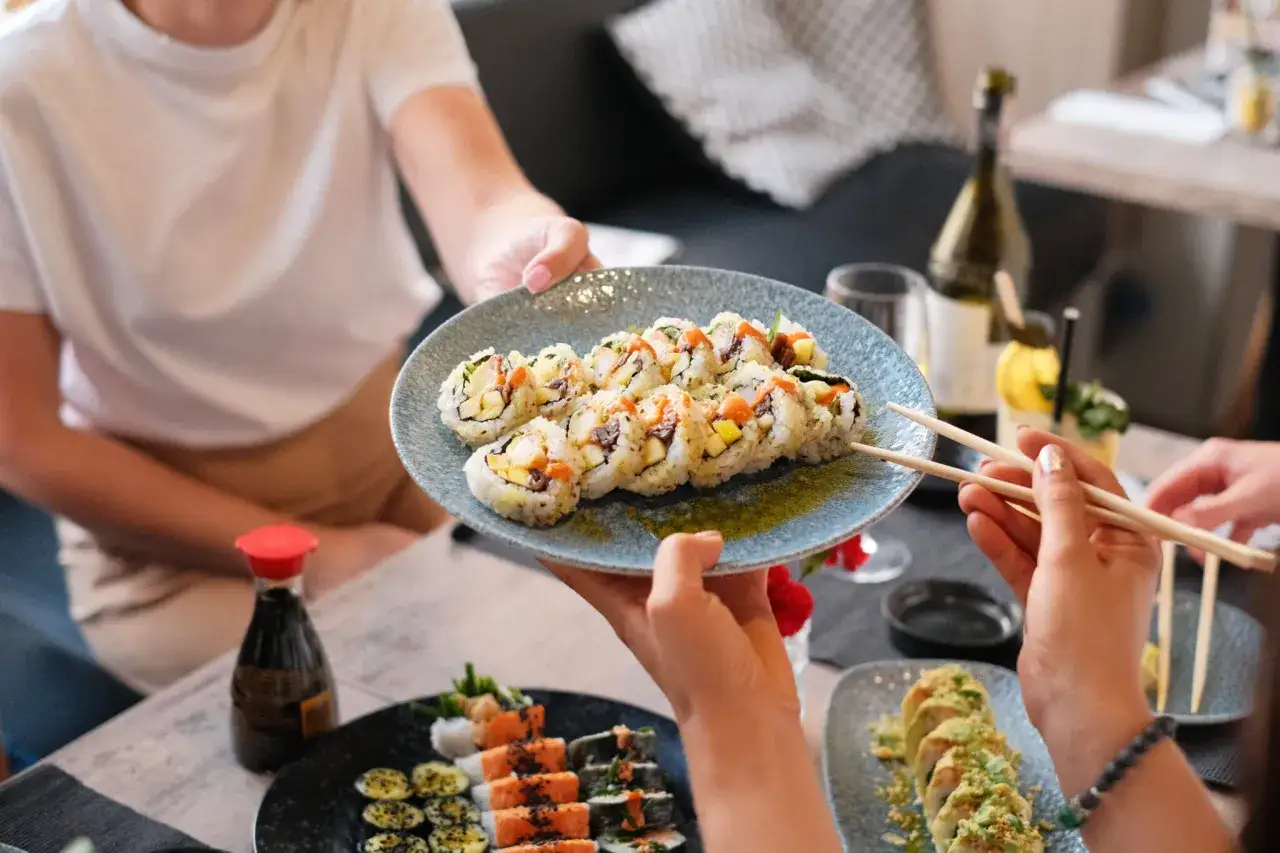 Talerz pełen sushi, które zachwyca kolorami i smakami. To kwintesencja kuchni japońskiej, idealna na wspólne spotkanie.