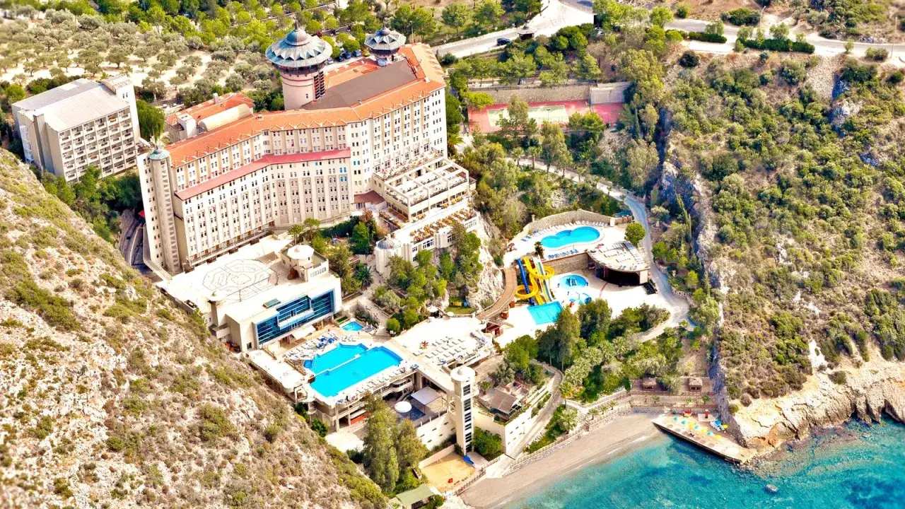 Widok z lotu ptaka na kompleks hotelowy z basenami, zjeżdżalniami i plażą. Wiele osób szuka ladonia hotels adakule opinie, by zaplanować wakacje.