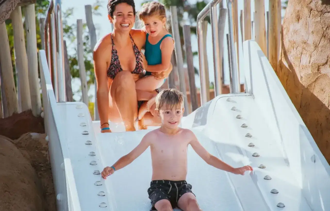 Familia disfrutando de un tobogán acuático, una idea genial para saber qué hacer en Salou con niños. ¡Diversión garantizada!