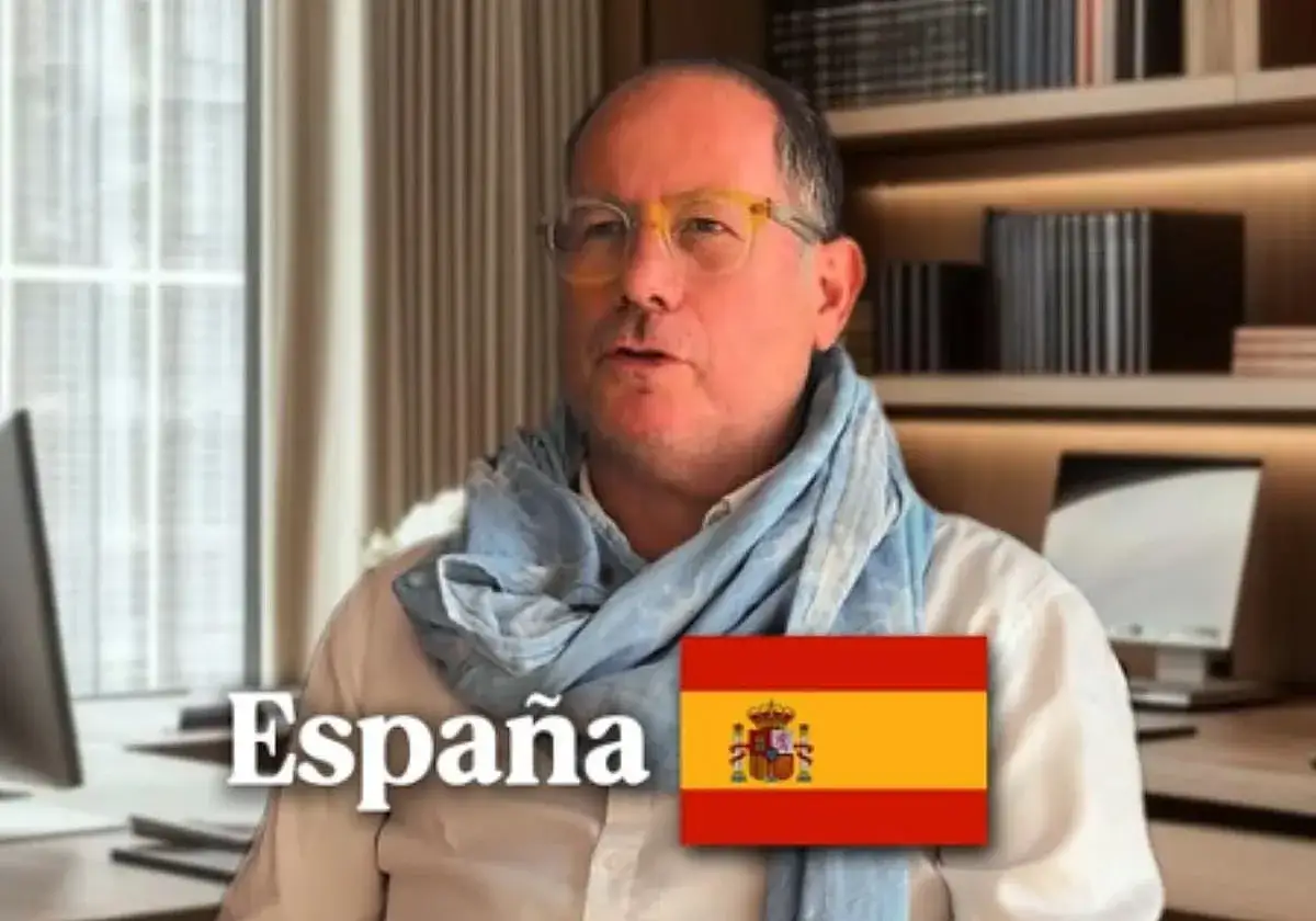 Hombre con bufanda azul y gafas amarillas, con la bandera de Espa&ntilde;a y el texto 