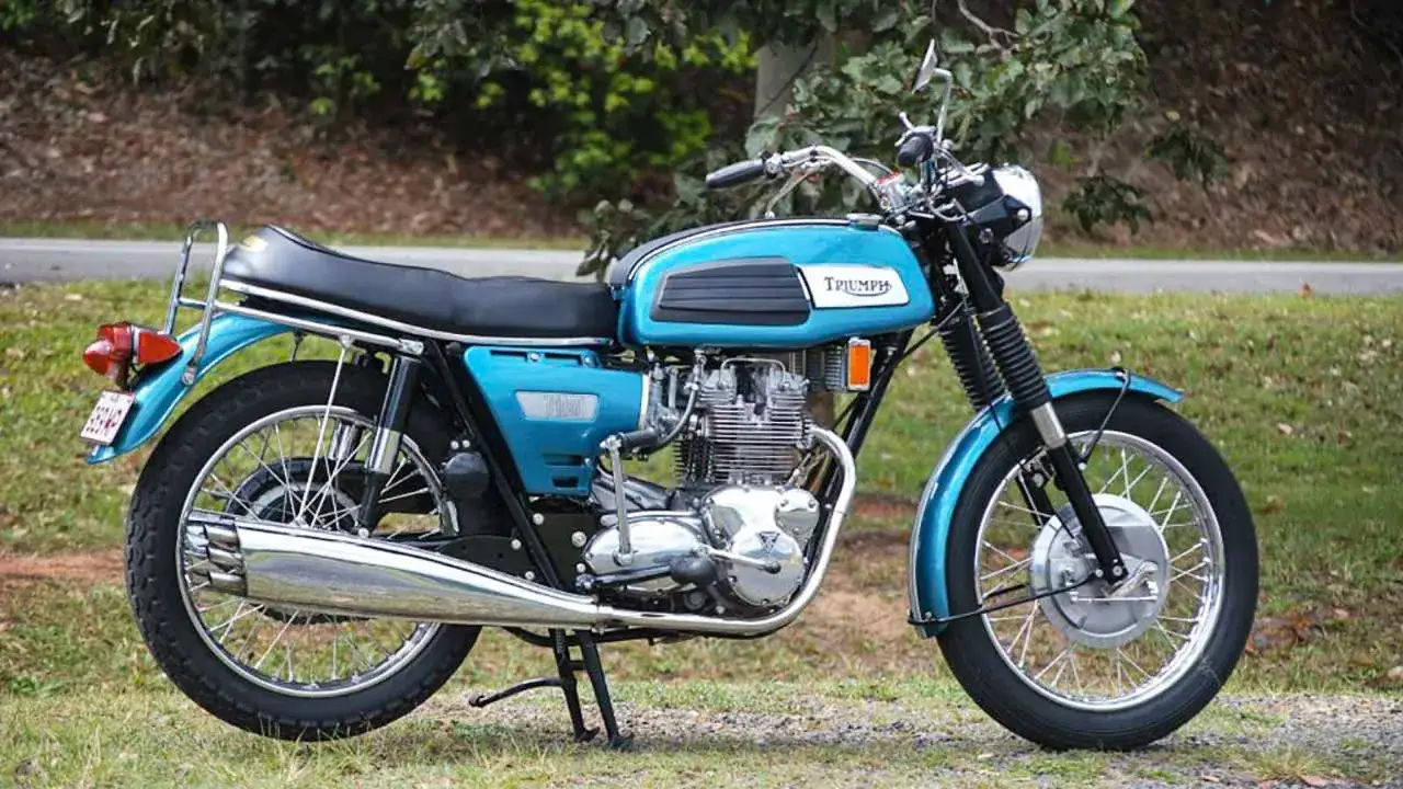 Cl&aacute;sica moto Triumph azul, un icono de las motos de los 60 y 70, lista para rodar.
