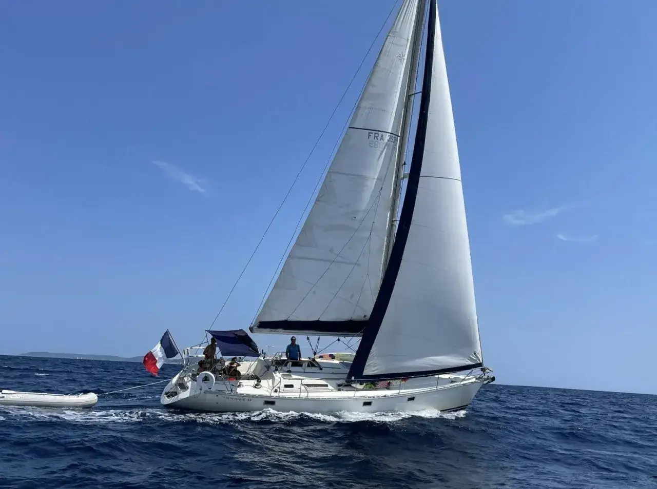 Un voilier SUN MAGIC 44 navigue sur une mer bleue sous un ciel clair. 44 avis sur cette belle journée.