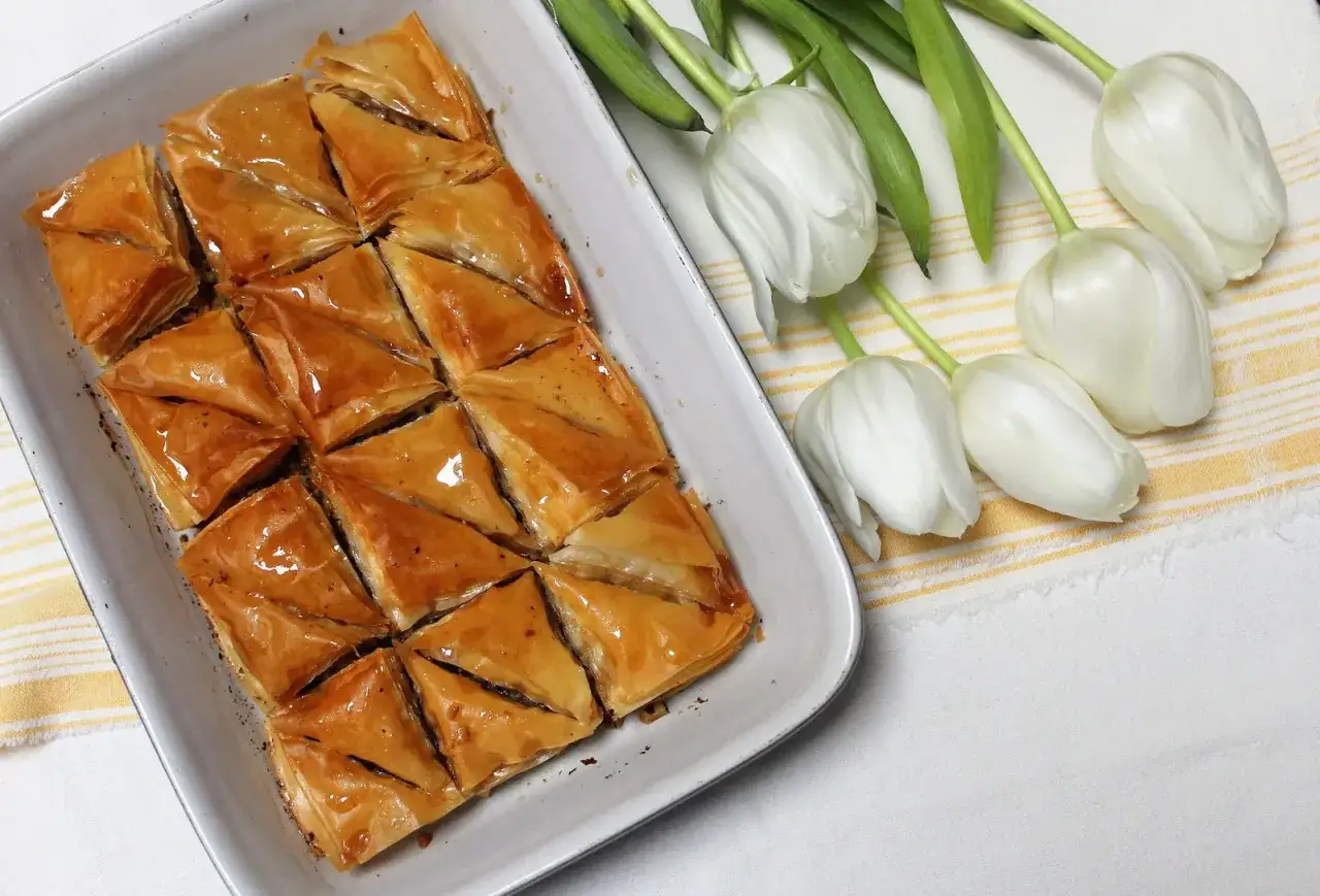 Un plat de baklava doré et sirupeux, prêt à être dégusté. Une recette parfaite pour les gourmands.