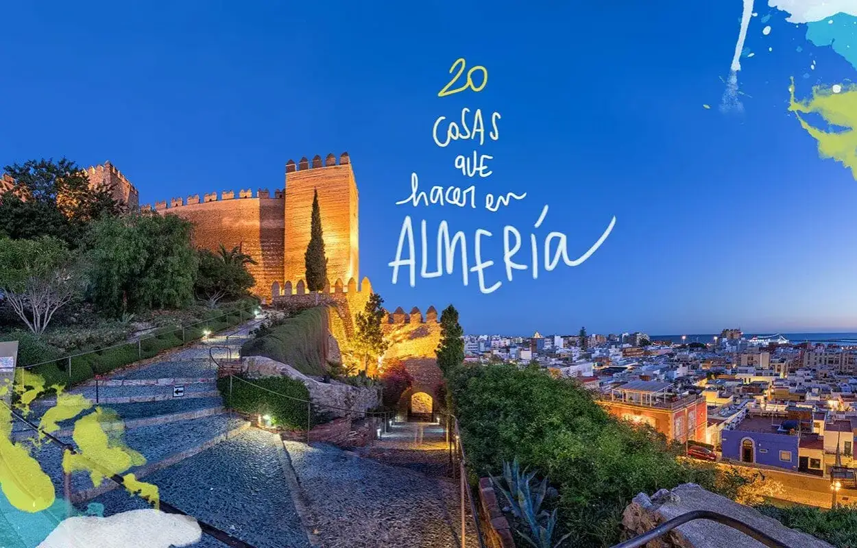 La Alcazaba iluminada al anochecer, un camino de piedra y la ciudad de Almería. ¡Ideas para visitar Almería capital!