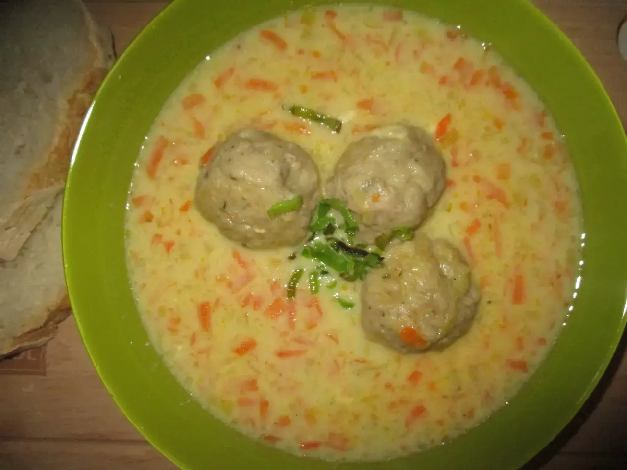 Aromatyczna zupa porowo serowa z pulpecikami, podana z chlebem.