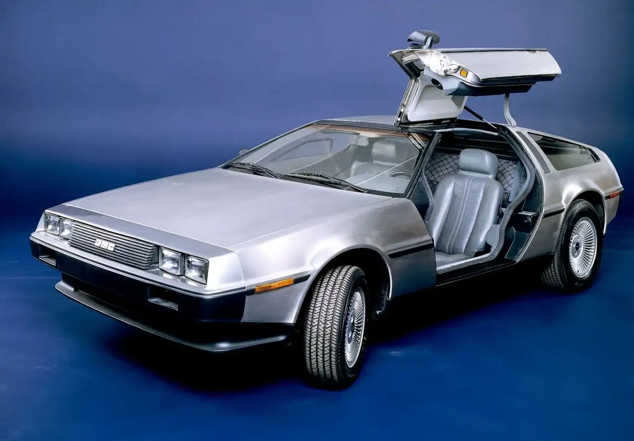 Srebrny DeLorean z otwartymi drzwiami typu gullwing, gotowy do podróży w czasie.