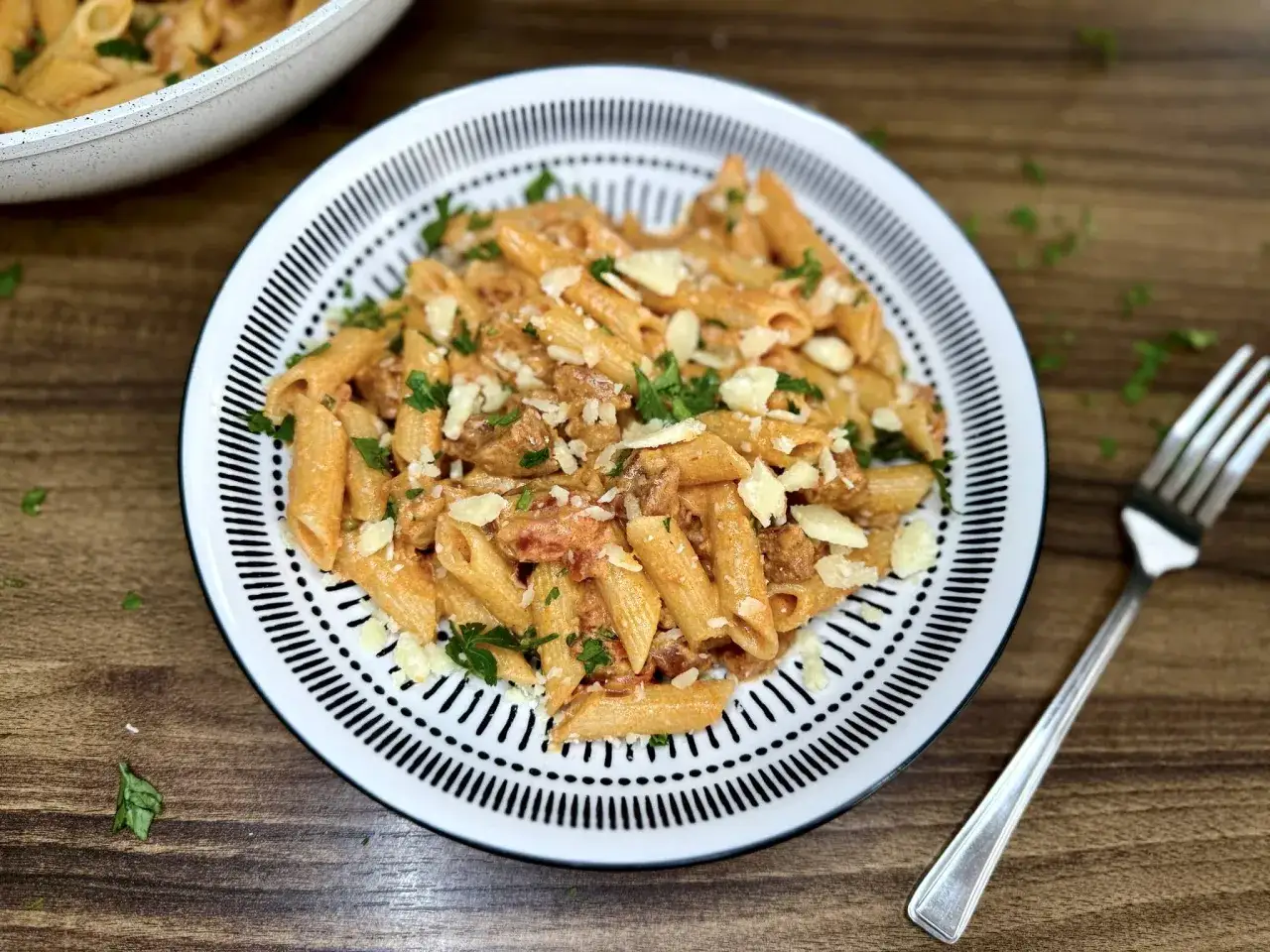 Penne z kremowym sosem pomidorowym i pikantnym chorizo, posypane parmezanem i natką pietruszki. Idealne danie dla miłośników makaronu.