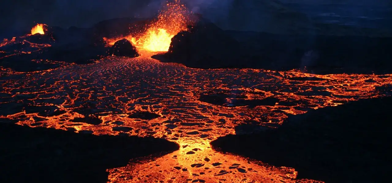 Gl&uuml;hende Lava flie&szlig;t aus einem Vulkan in Europa. Die hei&szlig;e, fl&uuml;ssige Gesteinsmasse bildet ein Netz aus leuchtend roten Str&ouml;men.