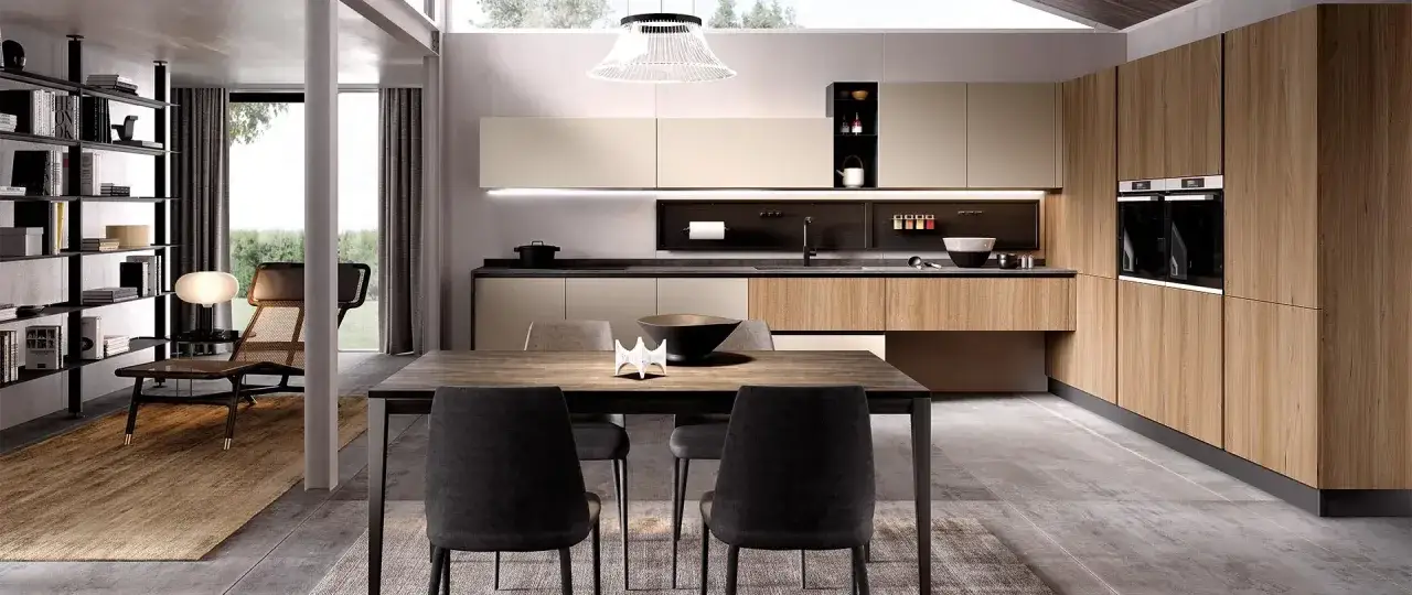 Cucina moderna con mobili in legno e finiture chiare, un tavolo con sedie nere e una libreria a vista. Ecco come abbellire una cucina moderna con stile.