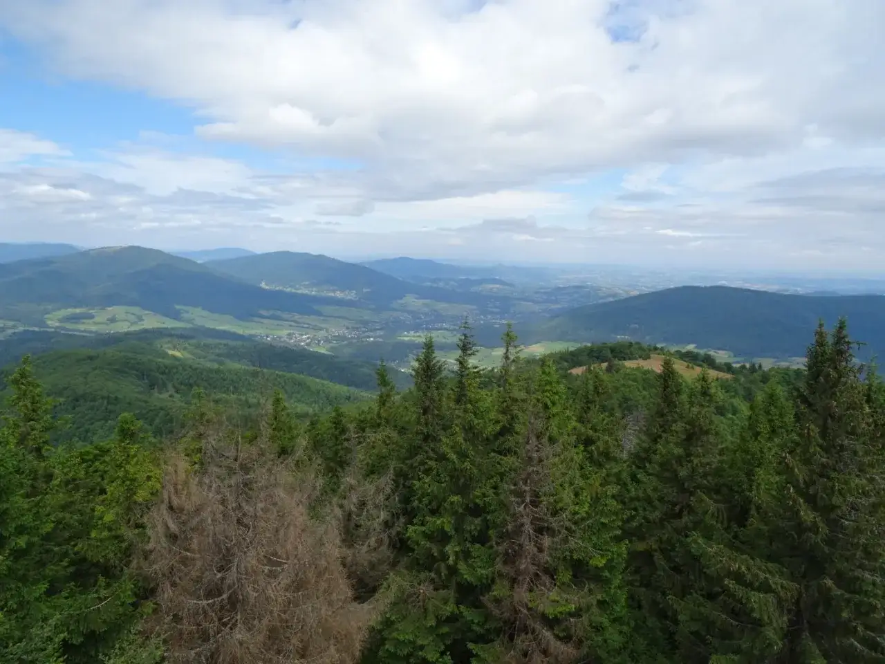 Widok z Mogielicy z Jurkowa na Beskid Wyspowy. W dole widać dolinę z zabudowaniami, a w oddali kolejne pasma g&oacute;rskie.