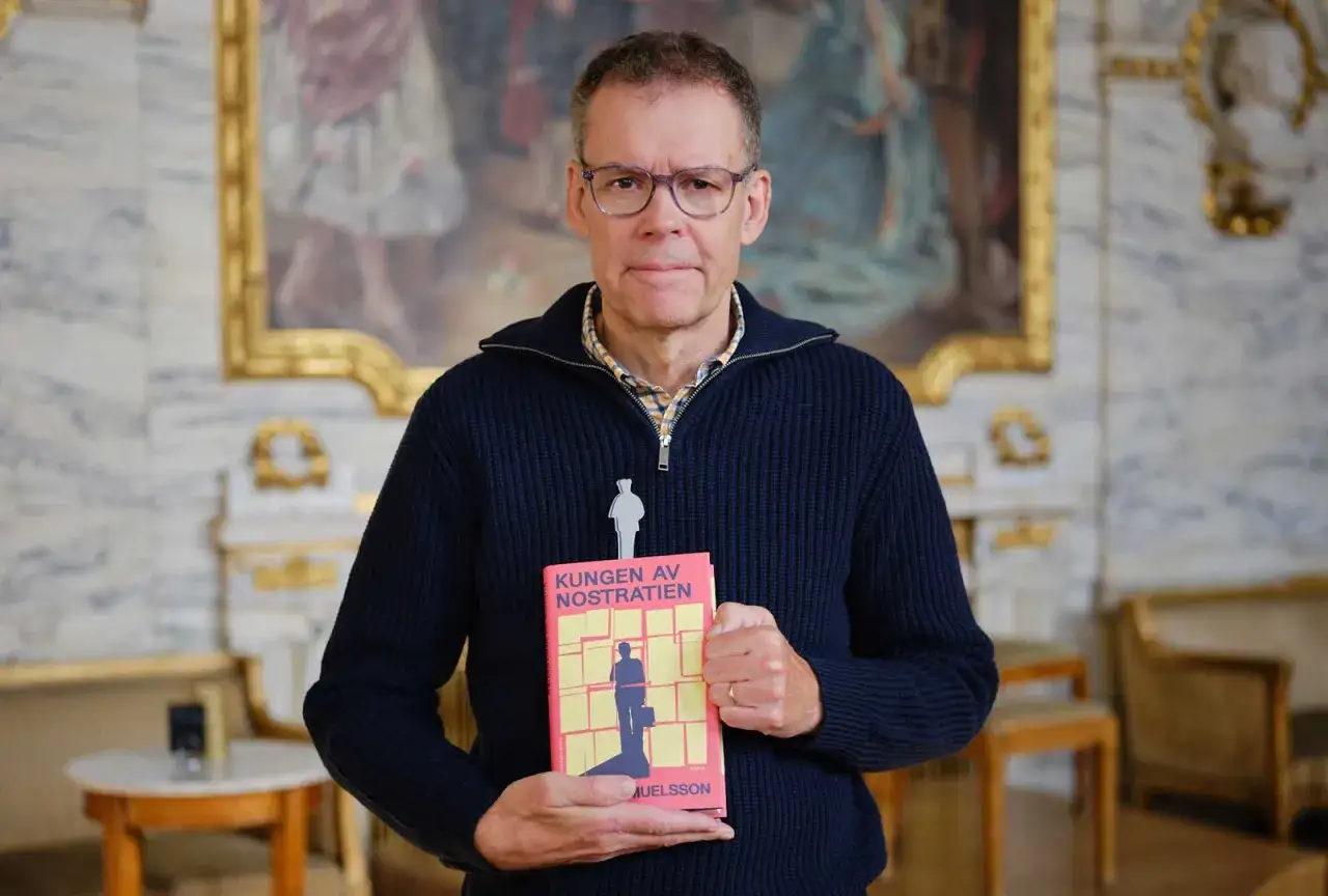 Tony Samuelsson håller upp sin bok