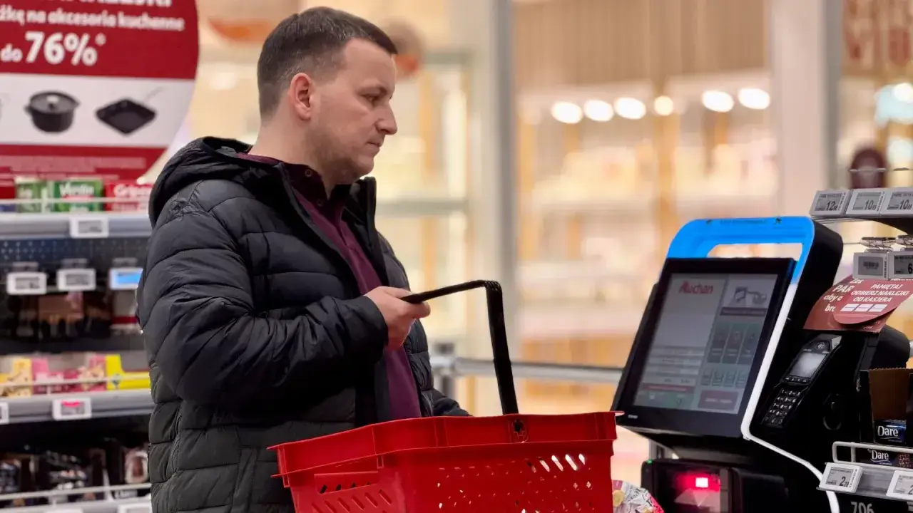 Mężczyzna z koszykiem przy kasie samoobsługowej. Czy to skutki wprowadzenia podatku od sprzedaży detalicznej dla konsumenta?