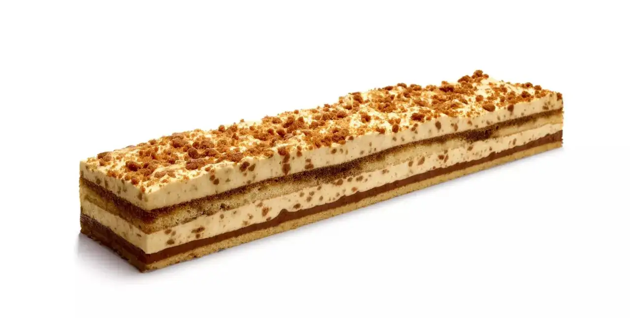 Gâteau rectangulaire aux couches de crème et de chocolat, garni de miettes de speculoos croustillantes.