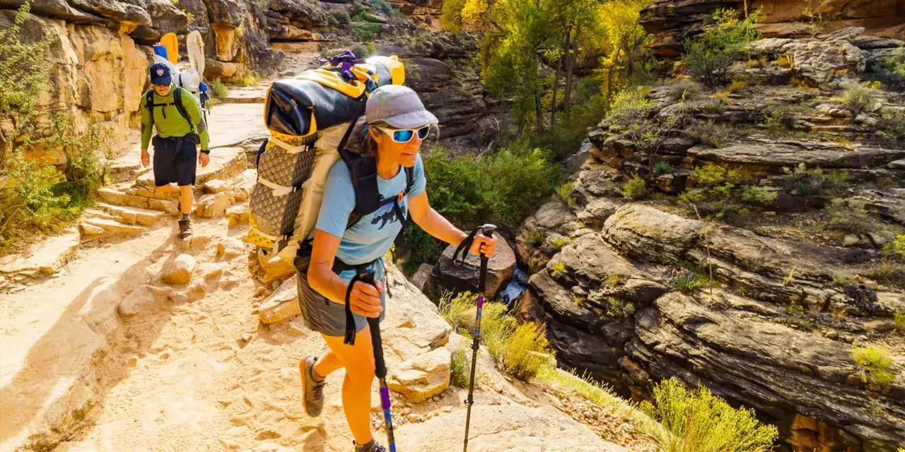 Ludzie z plecakami idą szlakiem w kanionie. To jest właśnie hiking &ndash; aktywność na świeżym powietrzu.