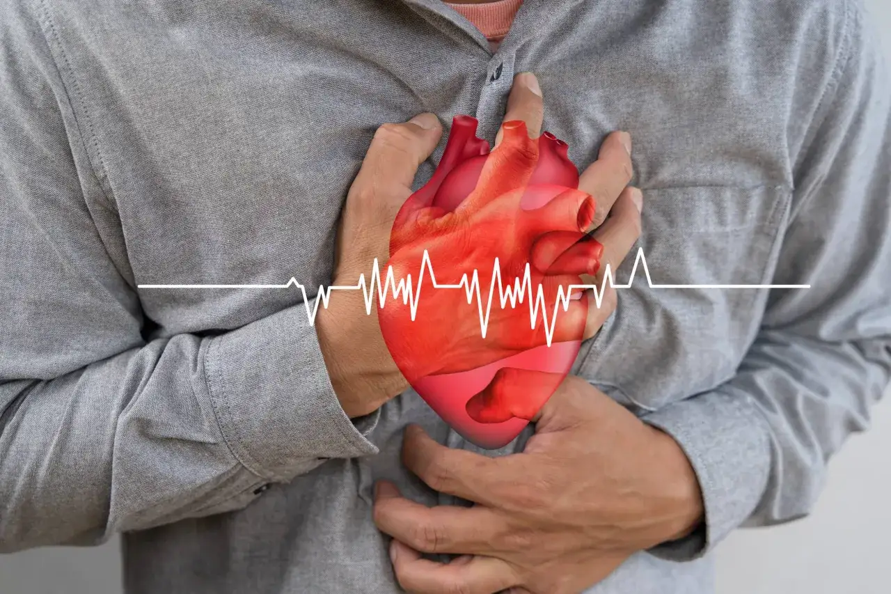 Mężczyzna trzyma się za serce, na którym widnieje wykres EKG. Może to symbolizować troskę o zdrowie serca, np. po zażyciu polfenonu.