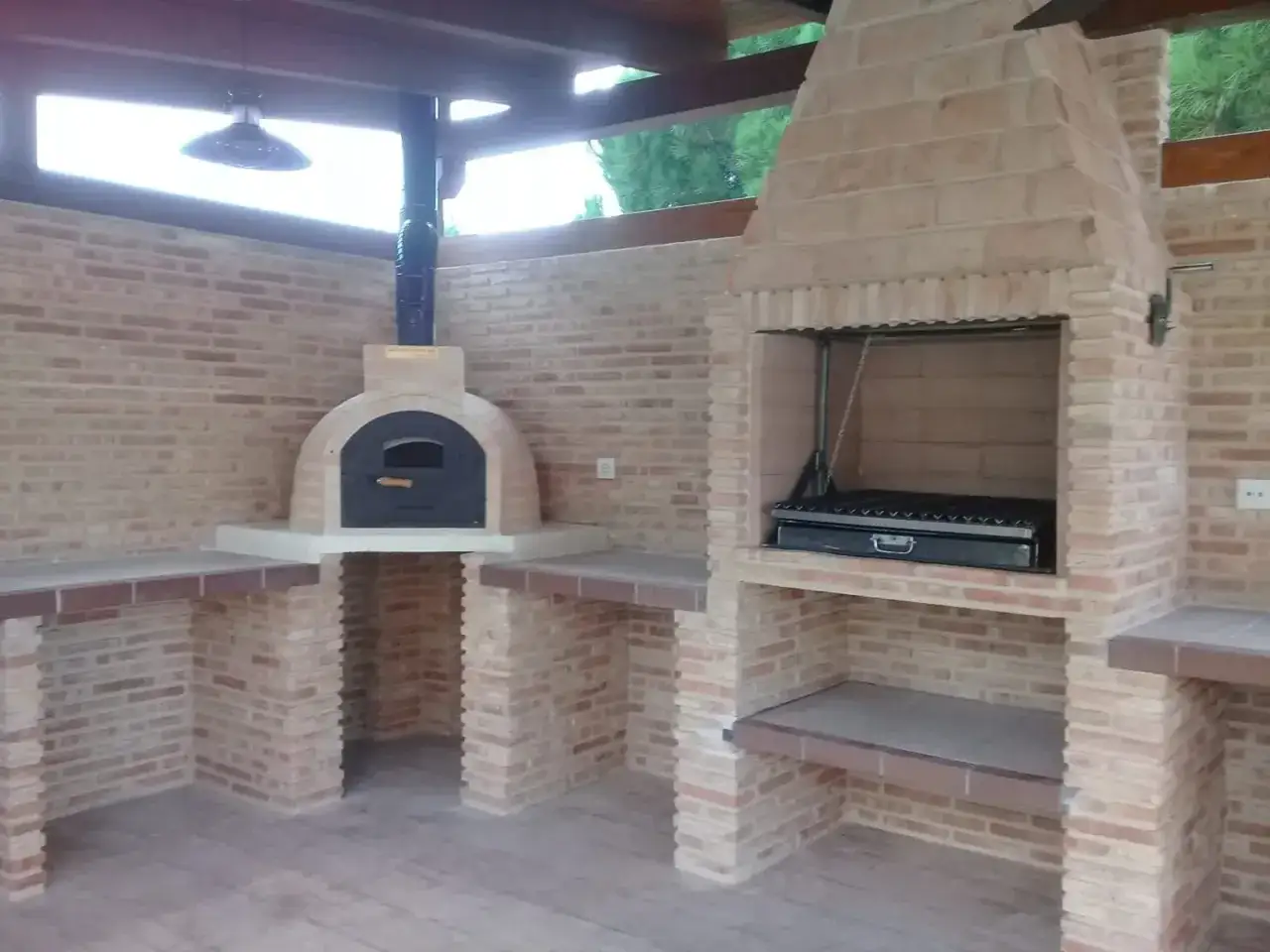 Un barbecue in muratura fai da te con forno a legna e griglia, perfetto per cene all'aperto.