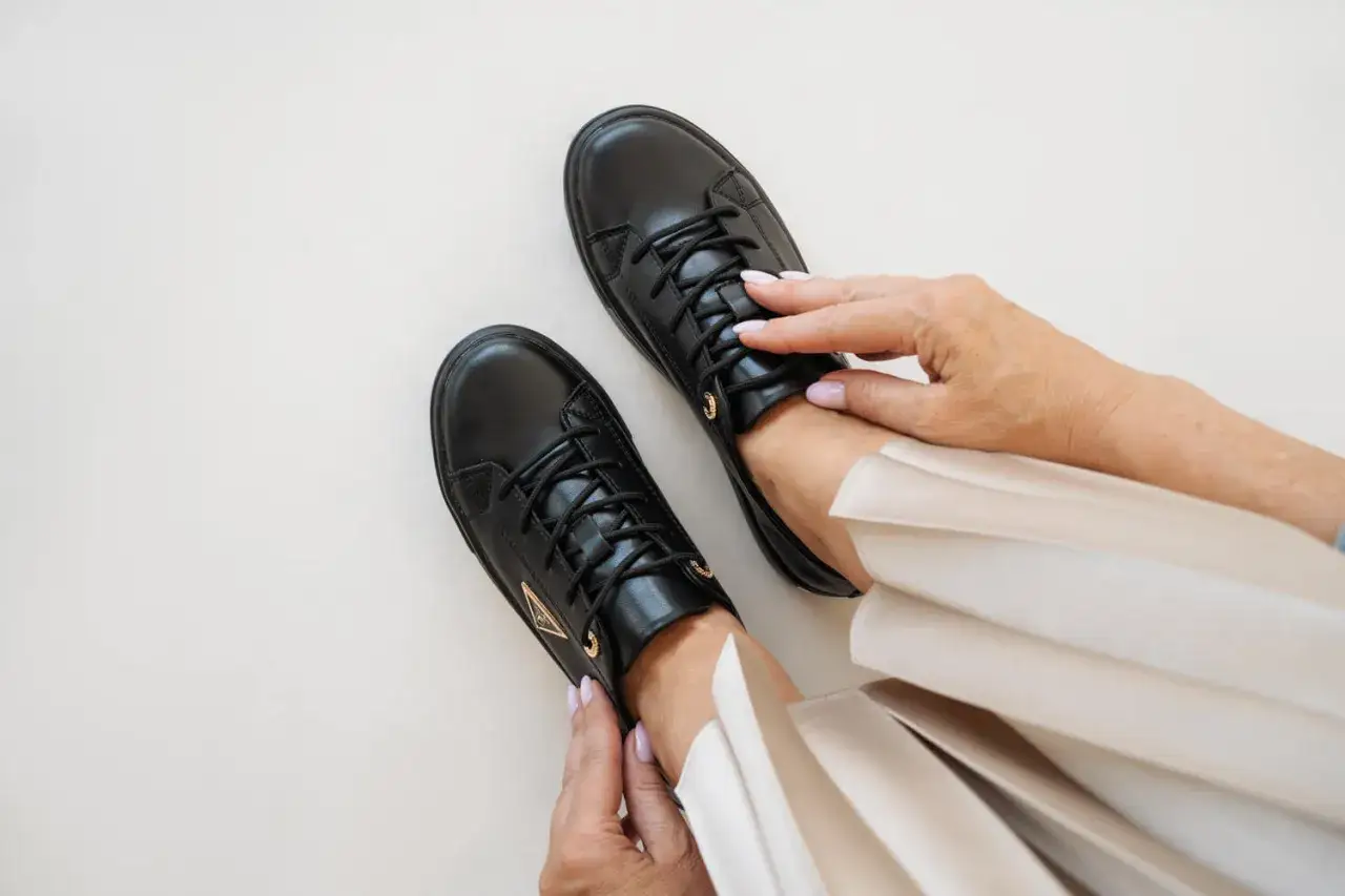 Czarne, skórzane sneakersy to idealne buty do damskiego garnituru, zapewniające komfort i styl.