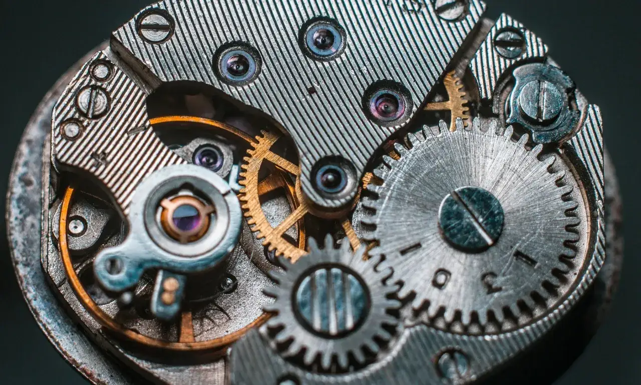 Meccanismo di un orologio automatico con ingranaggi dorati e argentati. Per capire come caricare orologio automatico, osserva questi dettagli.