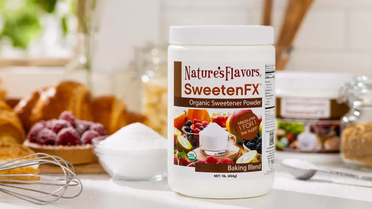 Le pot de poudre édulcorante biologique Nature's Flavors SweetenFX, avec des fruits et des viennoiseries en arrière-plan, suggère quel est le meilleur sucre naturel pour la pâtisserie.