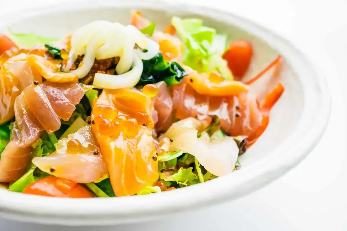 Deliziosa insalata di mare con verdure fresche, salmone affumicato, gamberi e uova di pesce. Un piatto colorato e saporito.