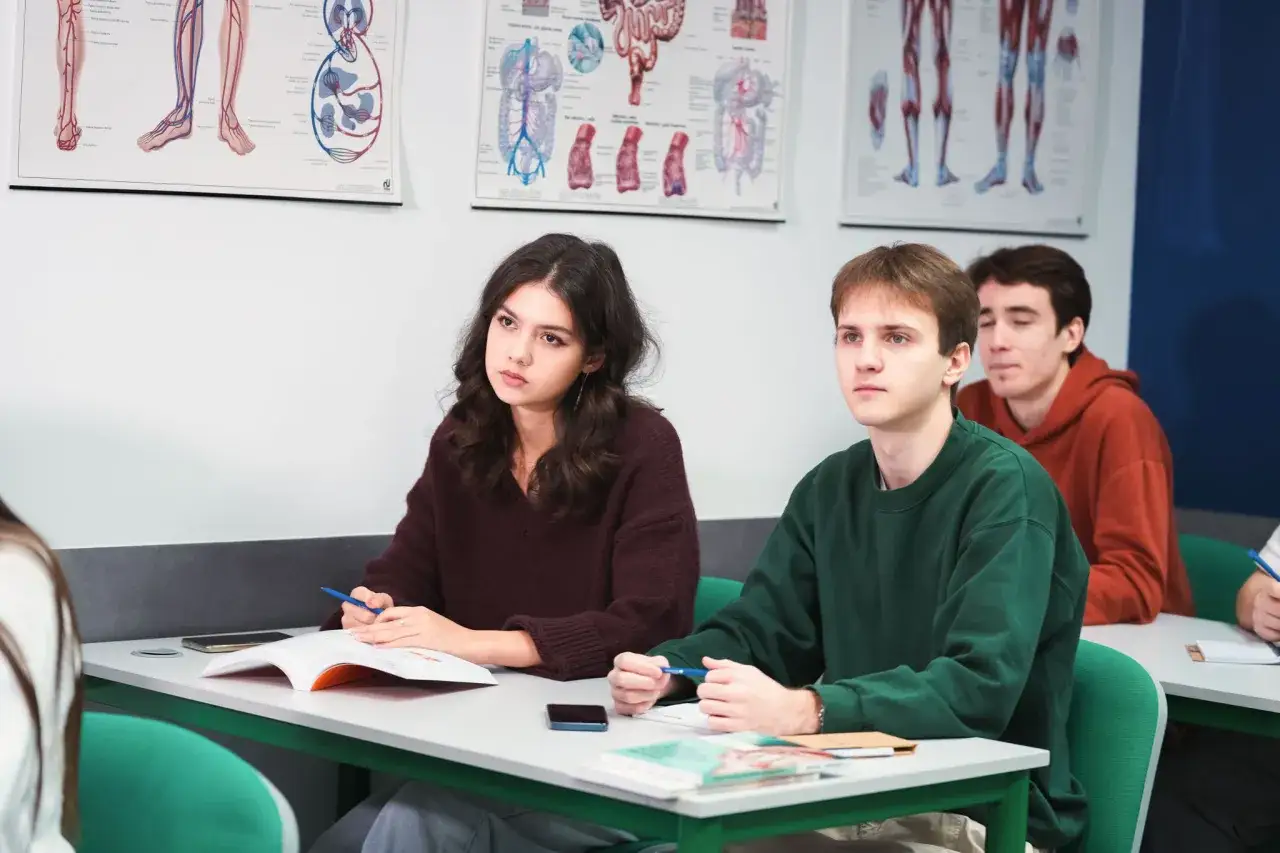 Studenci na zajęciach z neuropsychologii, skupieni na wykładzie. Na ścianach wiszą anatomiczne plansze.