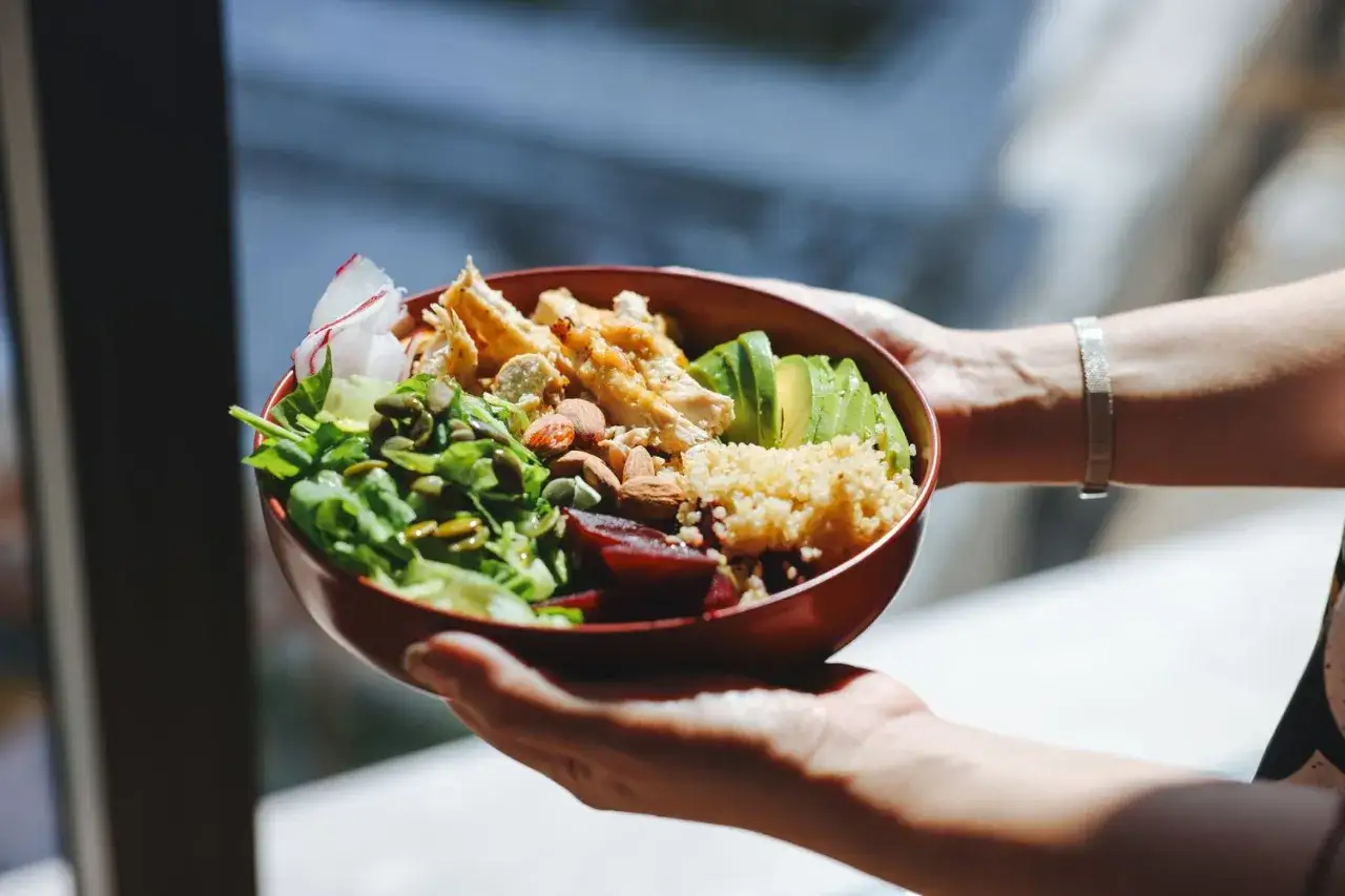Schüssel mit Hähnchen, Avocado, Quinoa und Gemüse. Perfekt für Krafttraining und Proteinbedarf.