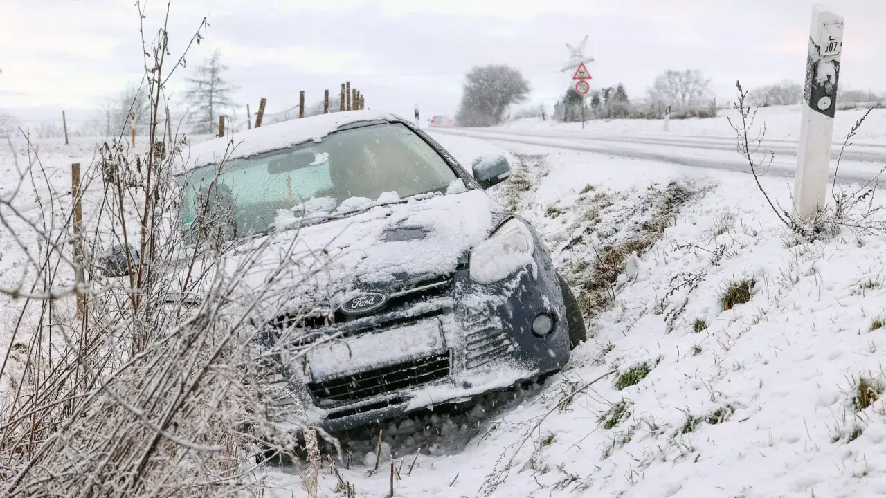 Schneebedeckter Ford im Graben, ein Beispiel für das **Wegerisiko für Arbeitnehmer** bei winterlichen Straßenverhältnissen.