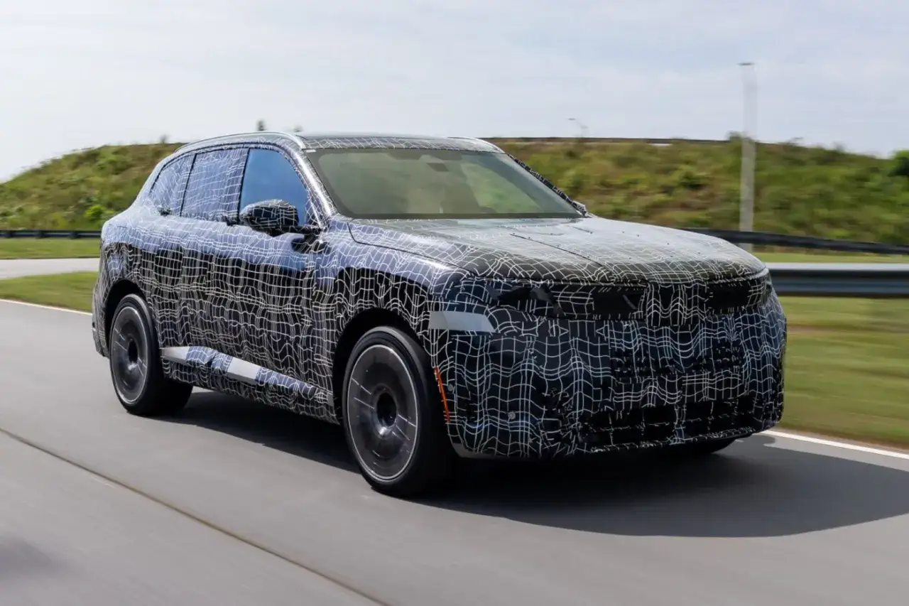 Der getarnte BMW iX5 Elektro f&auml;hrt auf einer Teststrecke.