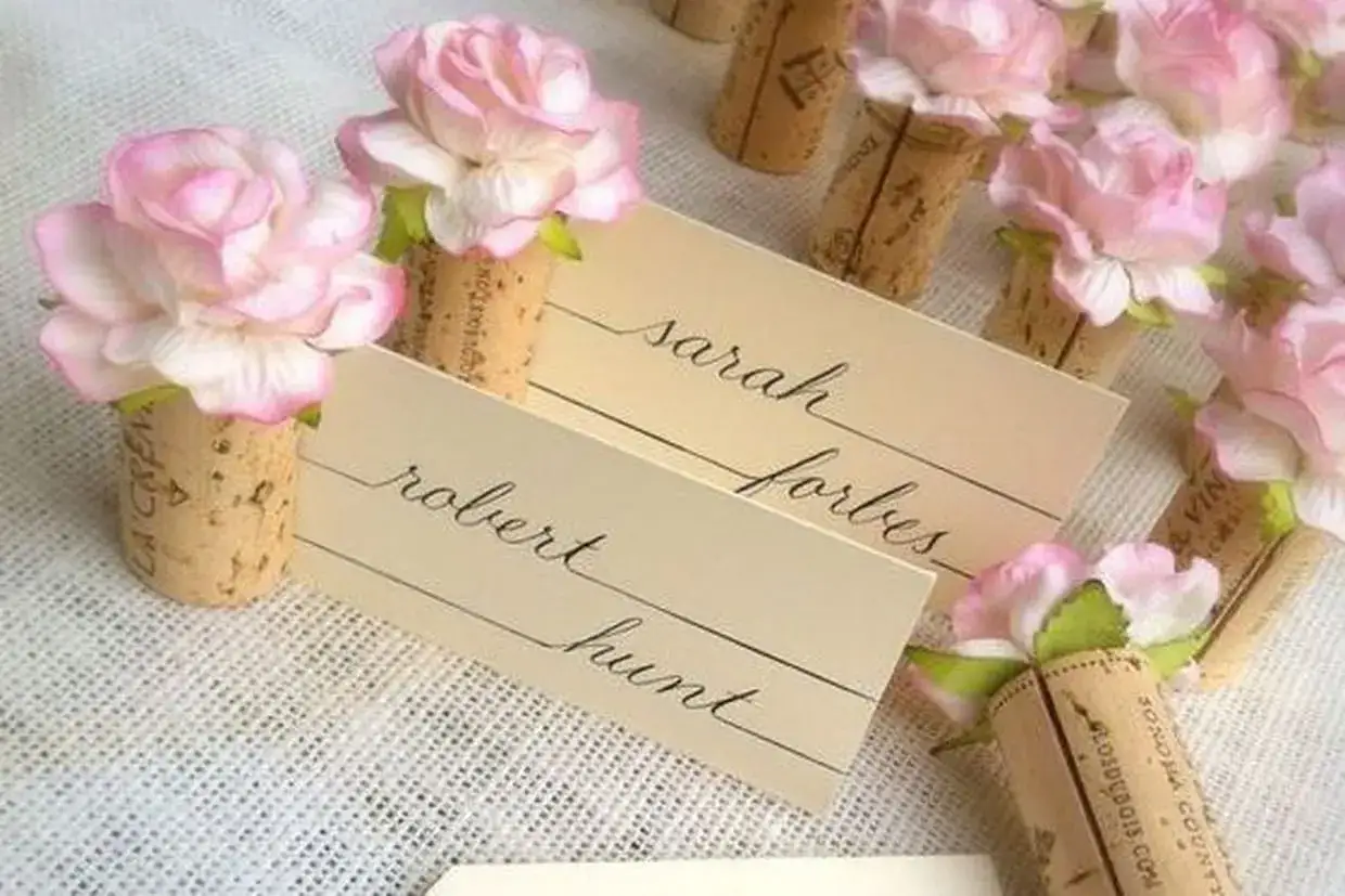 Marque-places DIY en bouchons de li&egrave;ge orn&eacute;s de roses roses. Id&eacute;al pour un mariage champ&ecirc;tre.
